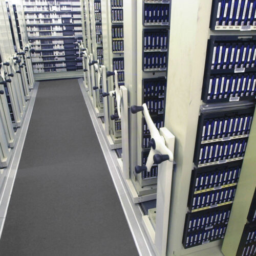 Archive shelving with organised media files in a Crown storage room.